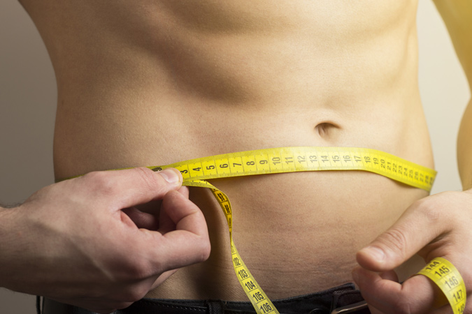 Man measuring his waistline